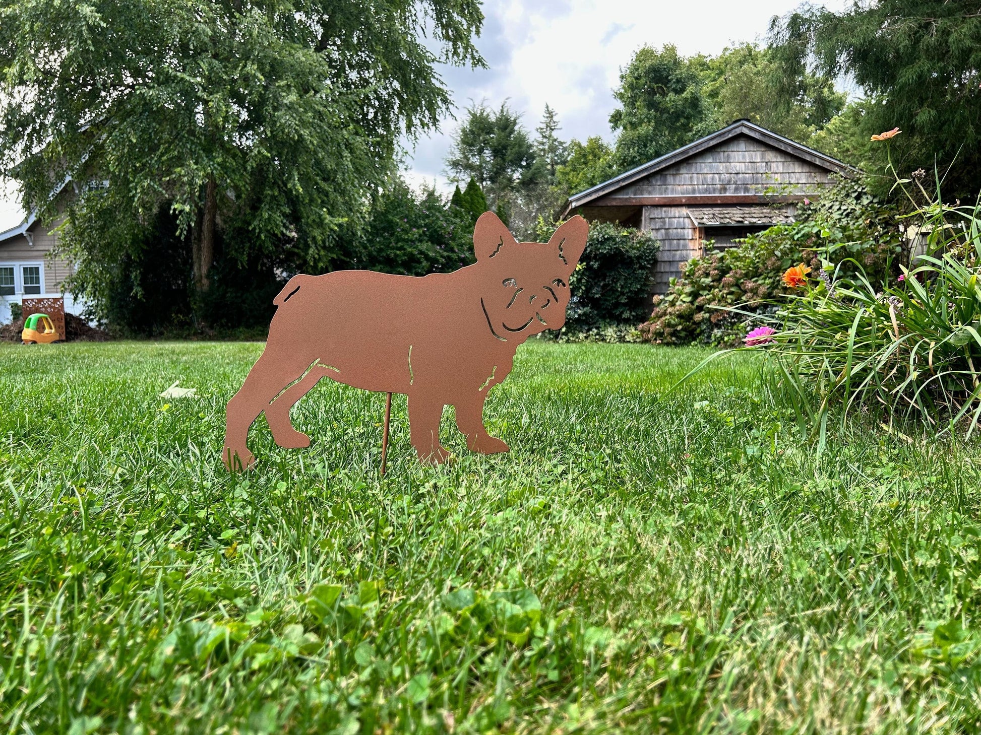 French Bulldog yard statue silhouette, rust-colored metal sculpture in a sunny yard on Tampa Home & Garden Store