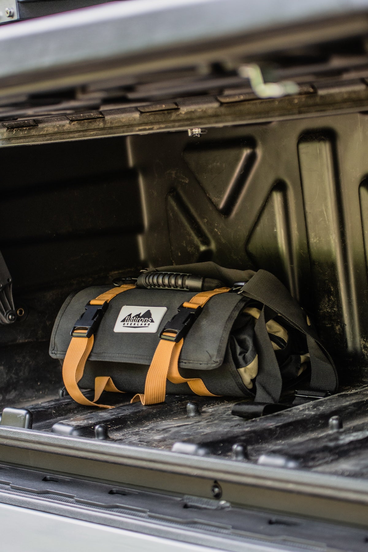 RiPouch Gear Roll by Flatirons Overland; dark gray tool roll with tan straps in a truck bed on Tampa Home & Garden Store