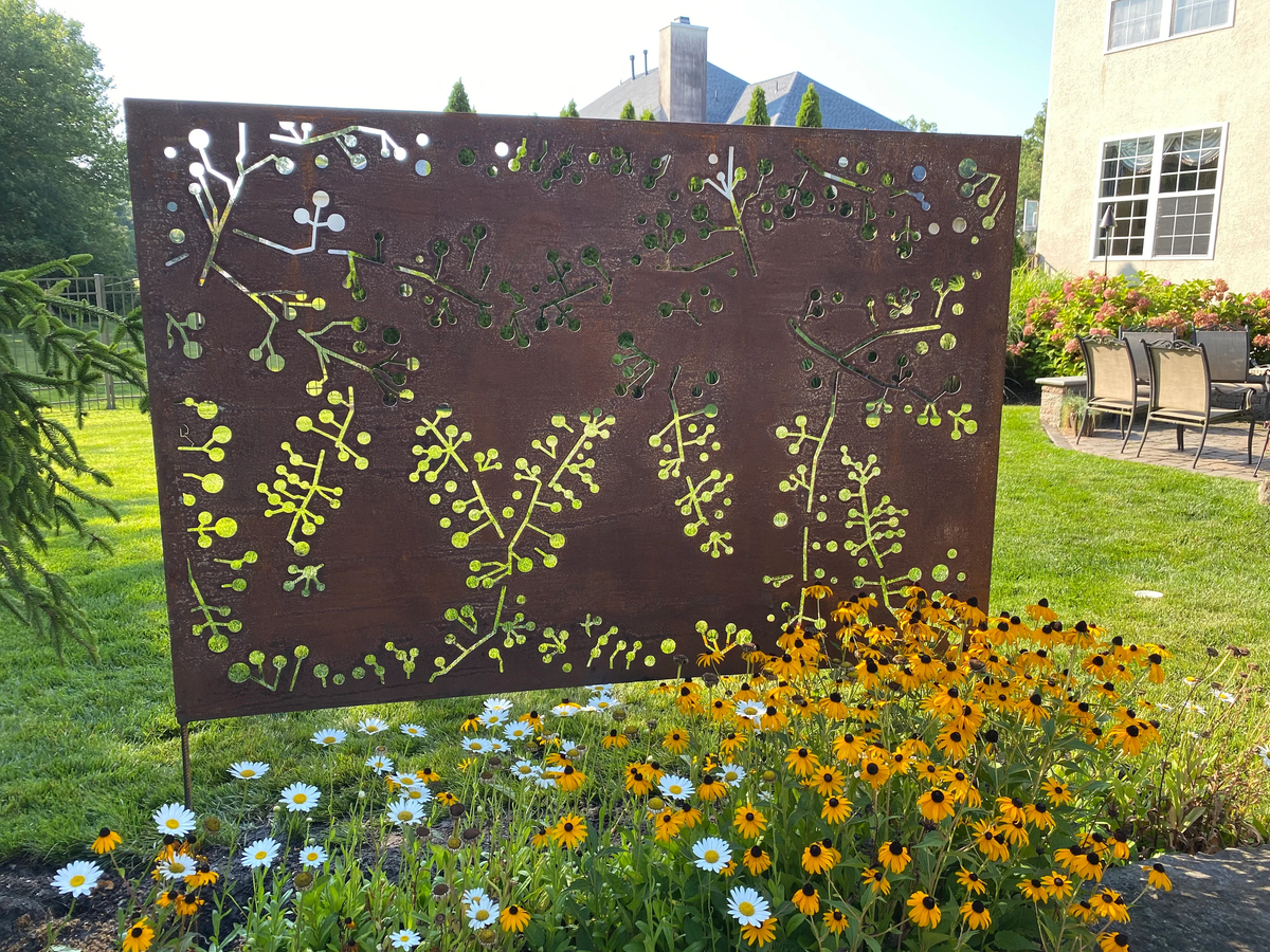 Outdoor metal privacy screen panel with wattle twig cutouts in rust on Tampa Home & Garden Store