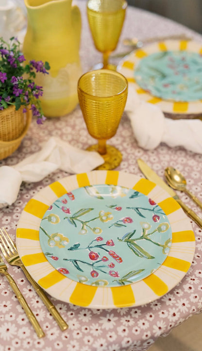 Set of Honeysuckle china plates turquoise floral with yellow striped rim on pink tablecloth on Tampa Home & Garden Store