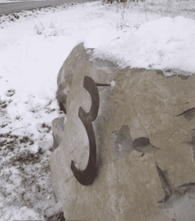 Mission Style decorative metal house number numeral in dark iron mounted on a snow-covered rock on Tampa Home & Garden Store