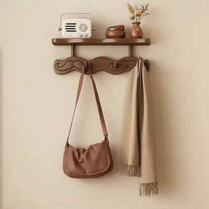 Bamboo wall coat rack with shelf and carved hooks, beige scarf and brown handbag hanging on Tampa Home & Garden Store