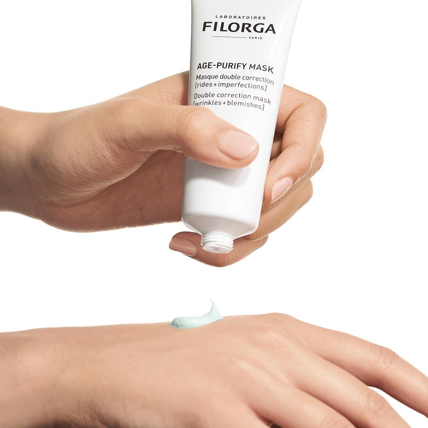 Filorga Purifying Double-Effect Mask tube dispenses mint-green cream onto hand on Tampa Home & Garden Store