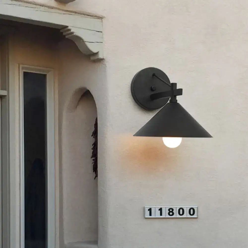 Black metal cone wall sconce by Decorbites mounted on beige exterior wall on Tampa Home & Garden Store