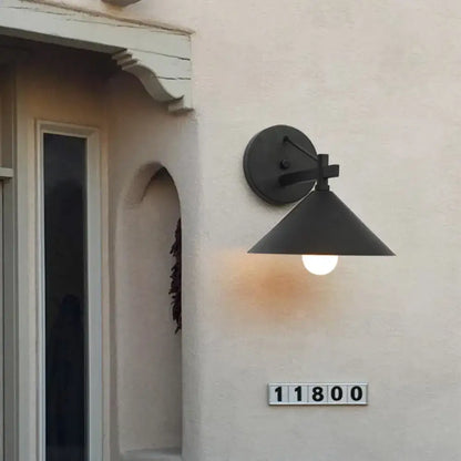 Black metal cone wall sconce by Decorbites mounted on beige exterior wall on Tampa Home & Garden Store