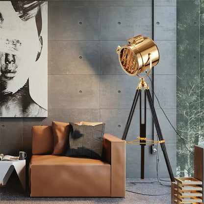 Decorbites tripod metal floor lamp with a gold spotlight head on black tripod legs on Tampa Home & Garden Store