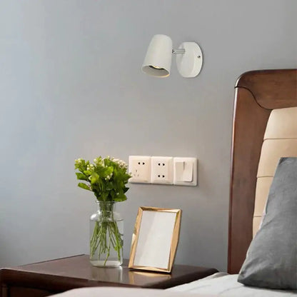 Nickel LED wall sconce Decorbites with white shade mounted on gray wall above bedside table on Tampa Home & Garden Store