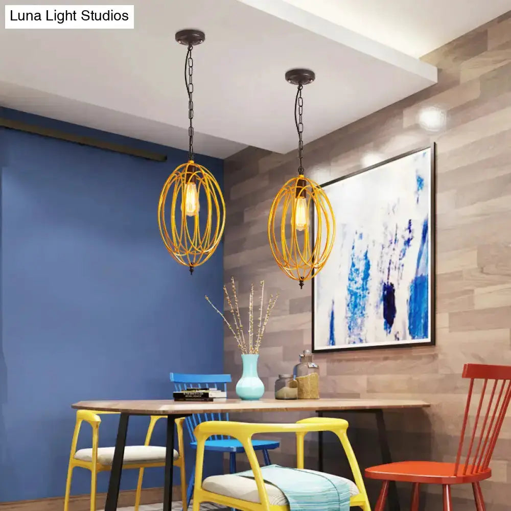 Industrial gray & red oval cage pendant light, two yellow pendants above a dining table on Tampa Home & Garden Store
