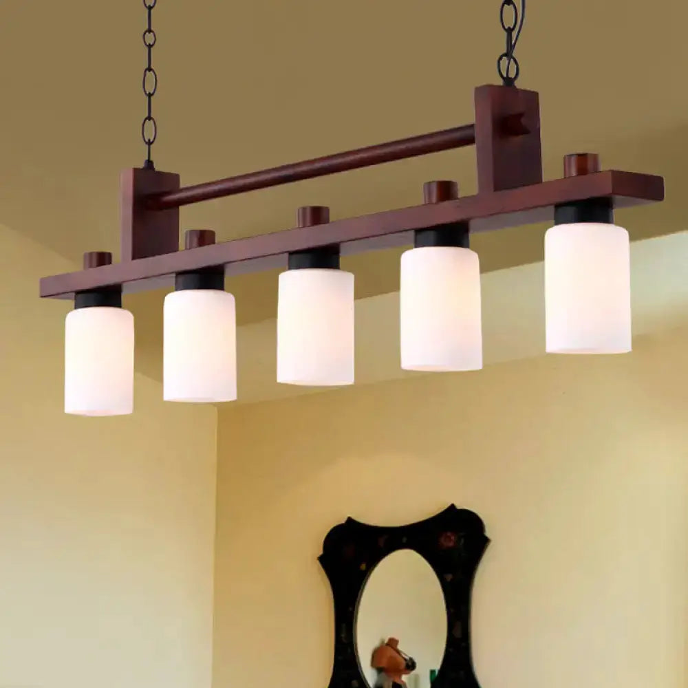 Traditional linear wood island pendant with opal glass shades, five white cylinders in dark wood on Tampa Home & Garden Store