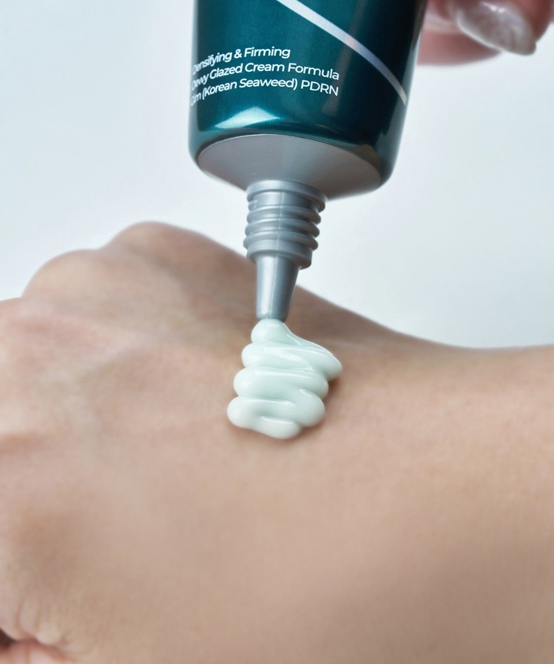 Isntree GIM PDRN Hydro Firming Cream teal tube dispenses pale cream onto skin on Tampa Home & Garden Store