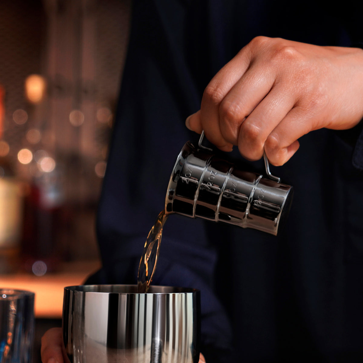 Gunmetal stepped jigger by Viski held over a polished cocktail shaker on Tampa Home & Garden Store