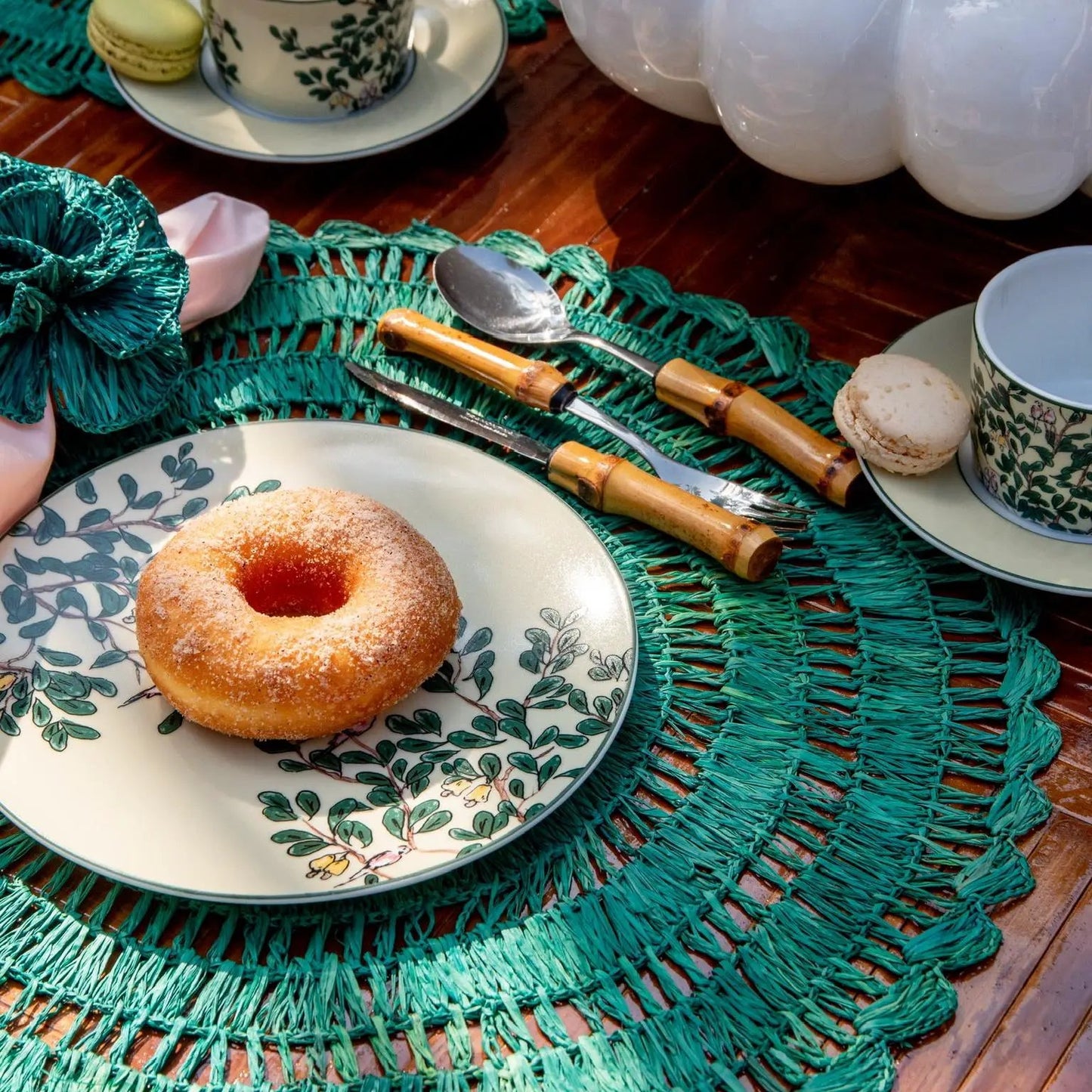 Buriti straw placemats in teal woven texture under a botanical dinner setting on Tampa Home & Garden Store