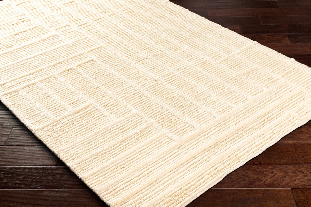 Kelburn Area Rug, cream textured pattern by Boutique Rugs on dark hardwood floor on Tampa Home & Garden Store