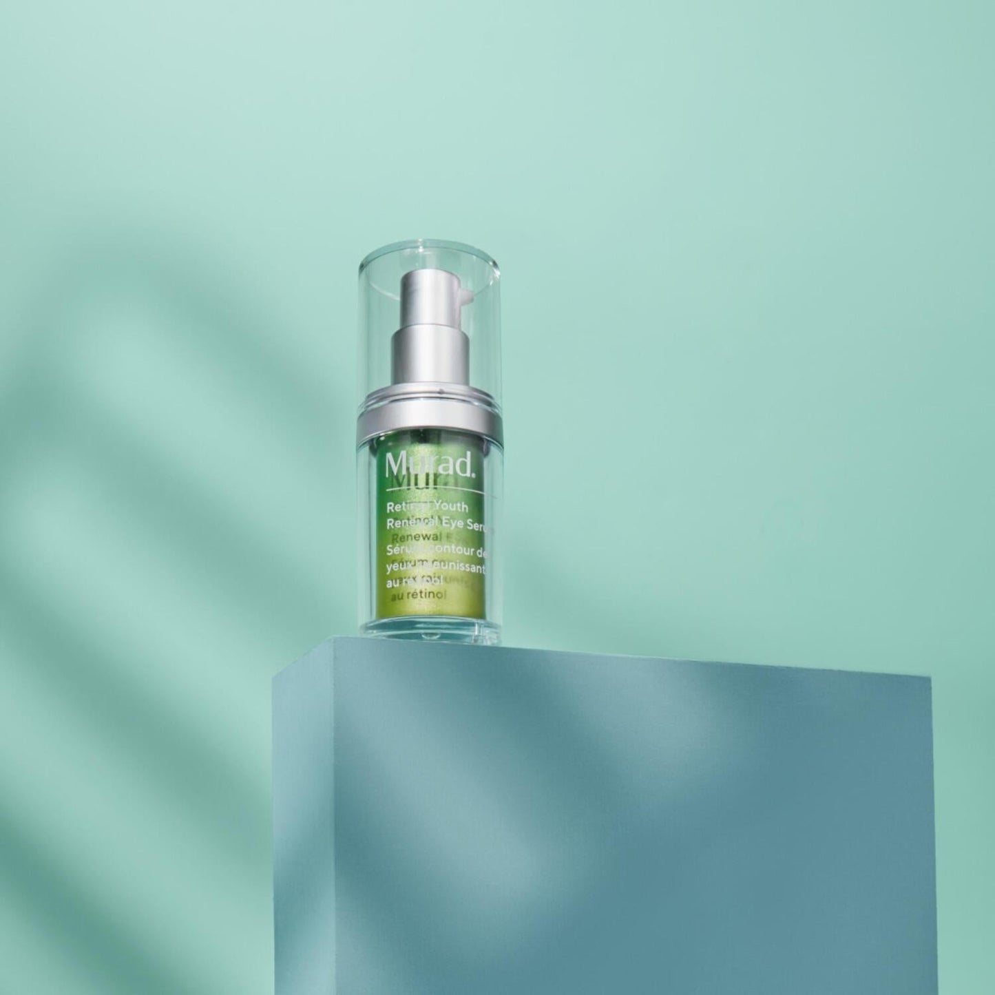 Murad Retinol Youth Renewal Eye Serum bottle with silver pump and clear cap on a teal pedestal on Tampa Home & Garden Store