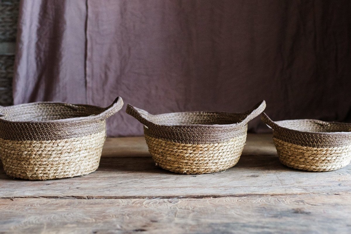 Khaki brown straw basket with handles, set of three woven baskets on a wooden table on Tampa Home & Garden Store