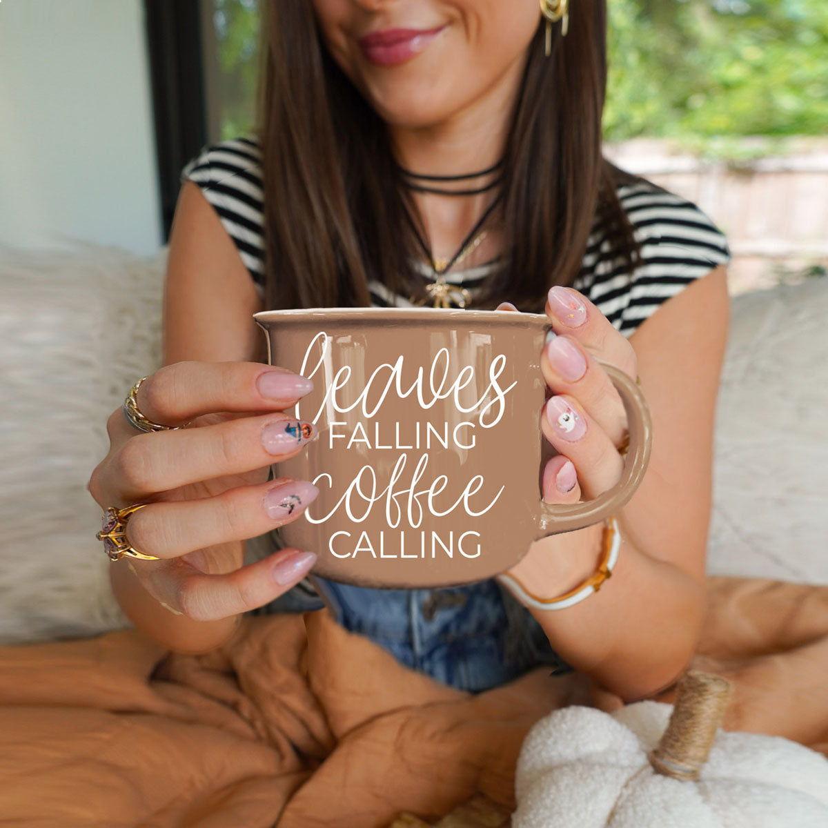 Gia Roma Leaves Falling coffee mug in tan ceramic with white script text, held by hands on Tampa Home & Garden Store