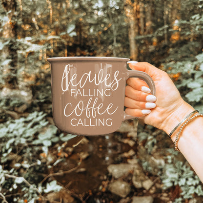 Leaves Falling coffee mug Gia Roma in taupe ceramic with white script, held in a forest setting on Tampa Home & Garden Store
