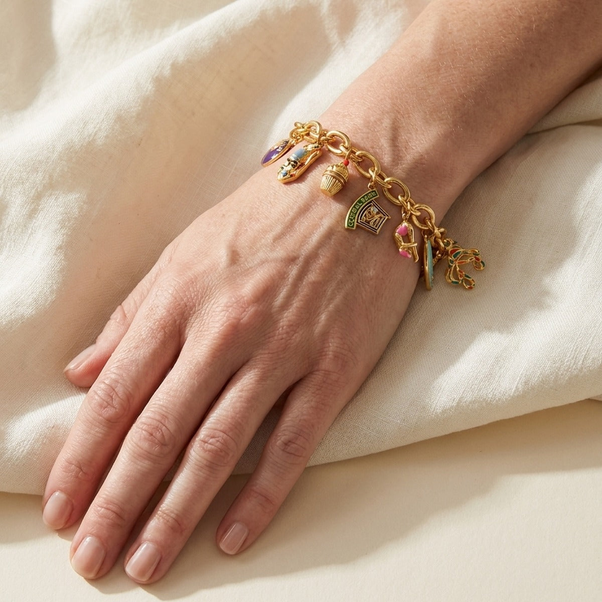 Eau Oasis Charm Bracelet by Lauren G Adams on a wrist, gold-tone chain with enamel charms on Tampa Home & Garden Store