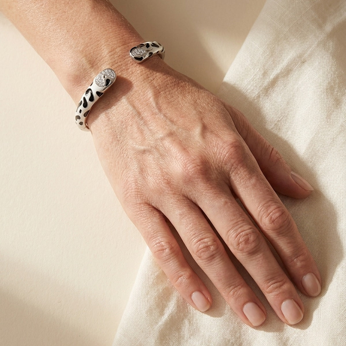 Sweet leopard hinged bangle bracelet in white with black spots and crystal heart clasp on wrist on Tampa Home & Garden Store