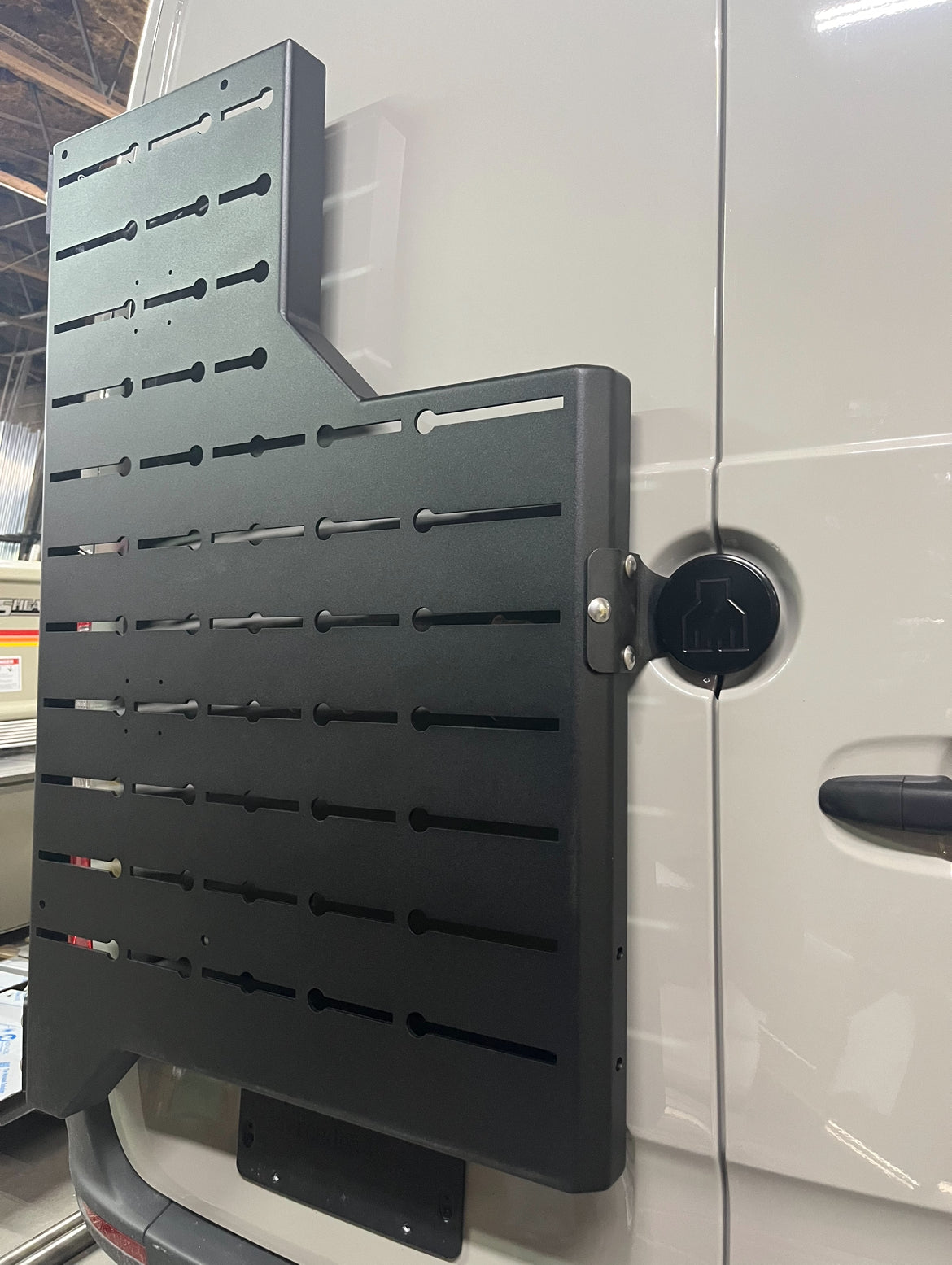 Outpost Sprinter Mounting Carrier mount on van door, black powder-coated steel slotted rack on Tampa Home & Garden Store