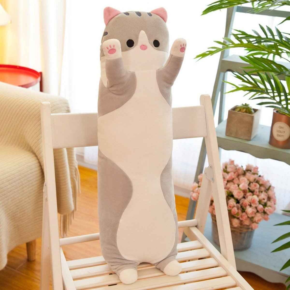 Shaketea 26in gray & white long cat plush pillow with pink paws standing on a white chair on Tampa Home & Garden Store