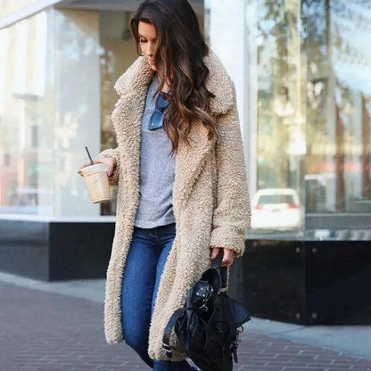 Stevvex beige faux shearling coat over gray top with blue jeans, holding coffee and black handbag on Tampa Home & Garden Store