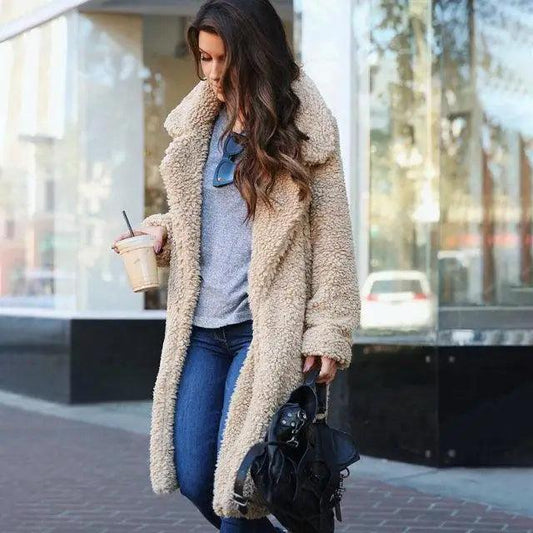 Stevvex beige faux shearling coat over gray top with blue jeans, holding coffee and black handbag on Tampa Home & Garden Store