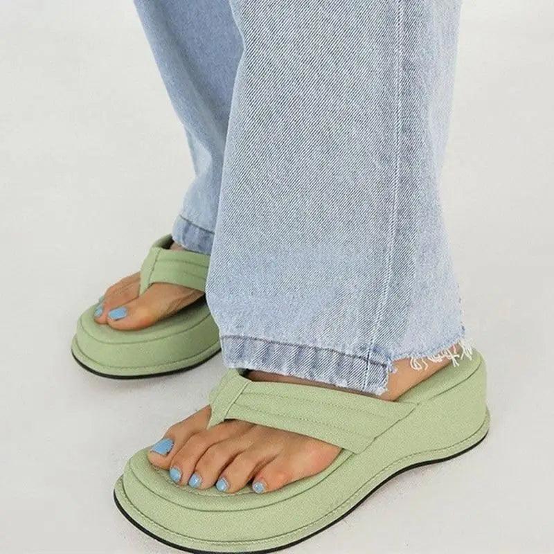 Sandals with wide straps and cushioned sole in green worn with jeans and blue toenails on Tampa Home & Garden Store