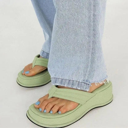 Sandals with wide straps and cushioned sole in green worn with jeans and blue toenails on Tampa Home & Garden Store