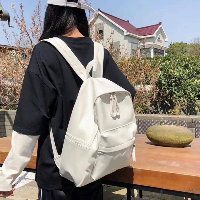 Stevvex cream white PU leather backpack with front pocket and dual zippers, worn by a person in a black shirt on Tampa Home & Garden Store
