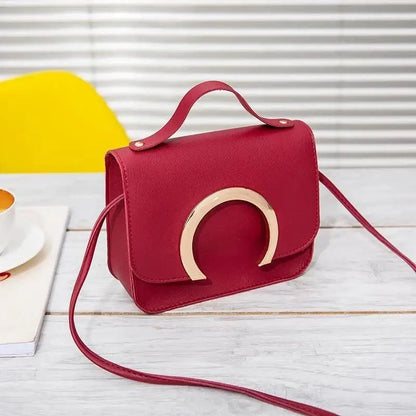 Crossbody bag red PU leather with gold-tone circular arch accent, top handle and long strap on Tampa Home & Garden Store