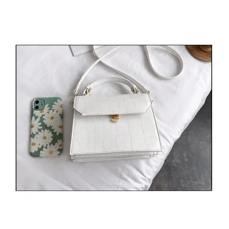 White croc-embossed PU crossbody bag with handle and gold clasp; daisy phone case nearby on Tampa Home & Garden Store
