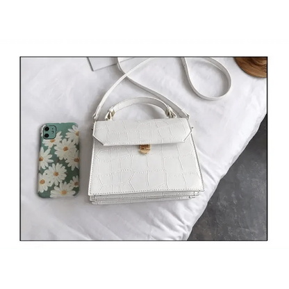 White croc-embossed PU crossbody bag with handle and gold clasp; daisy phone case nearby on Tampa Home & Garden Store