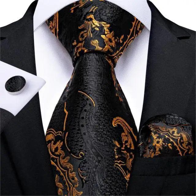 Silk necktie with black and gold floral pattern and matching pocket square on black suit on Tampa Home & Garden Store