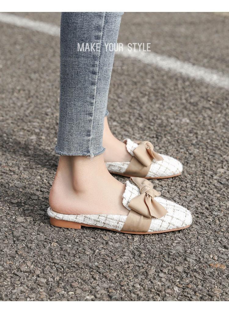 Pair of close-toe women's flats with beige bow on white tweed fabric, casual flat-heel slippers worn with jeans on asphalt on Tampa Home & Garden Store