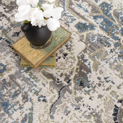 Cabacungan Gray & Blue Washable Area Rug with black vase, white flowers atop books on Tampa Home & Garden Store