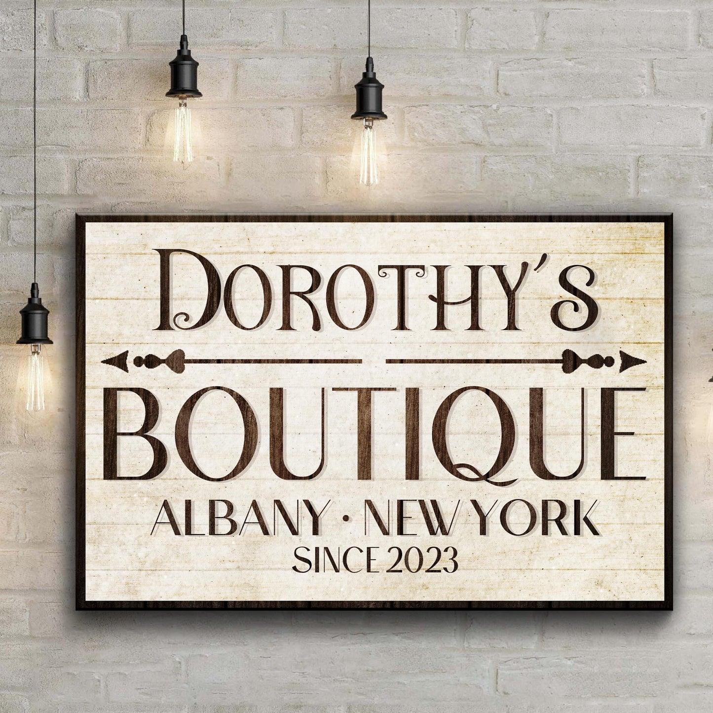 Boutique Sign IV canvas with vintage serif text on a brick wall Edison bulb lighting on Tampa Home & Garden Store