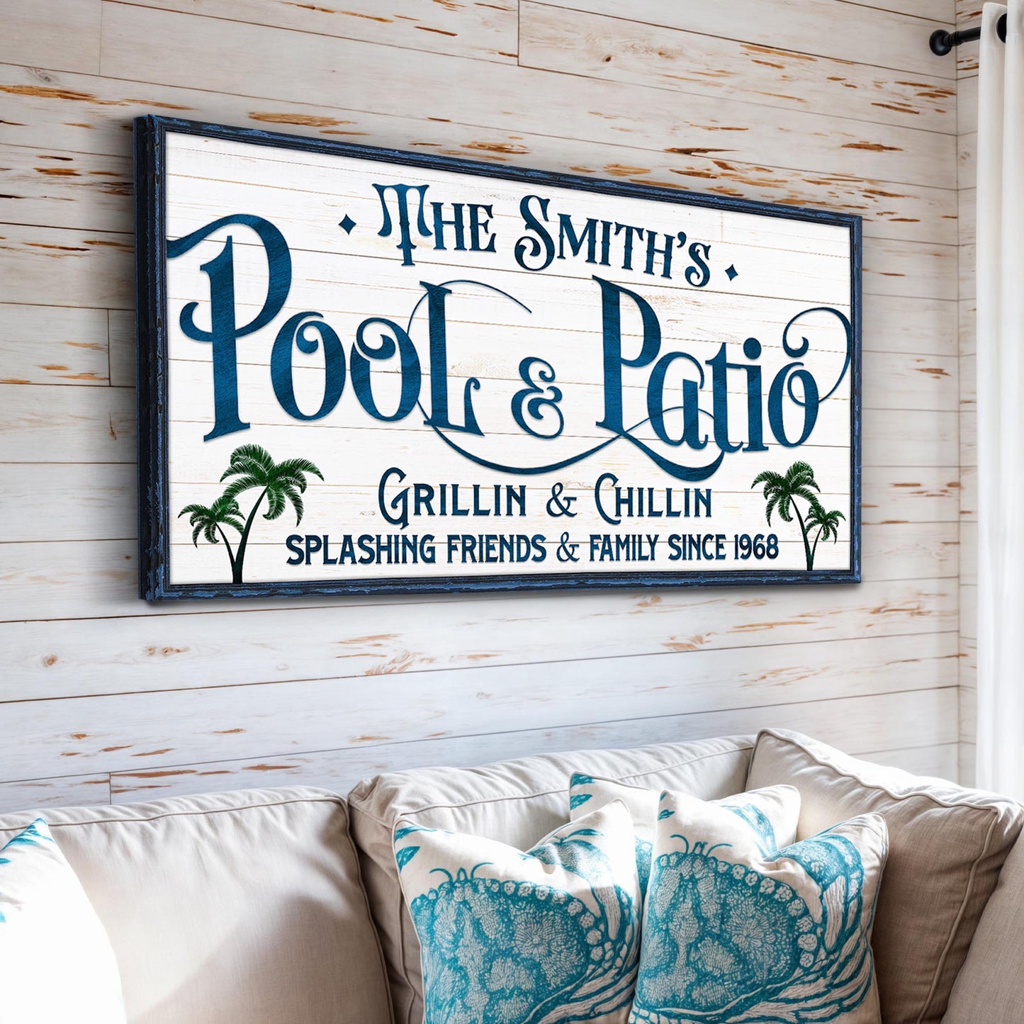 Personalized Pool Bar Sign II canvas by Tailored Canvases with blue ornate lettering, palm trees and a dark blue frame on whitewashed wood backdrop on Tampa Home & Garden Store