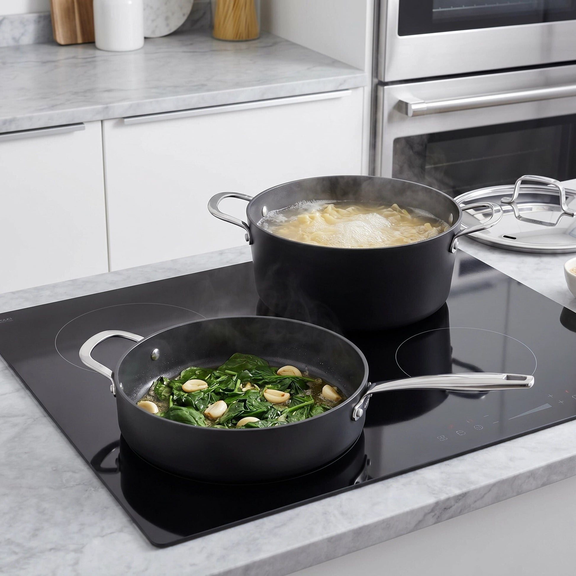 Ceramic nonstick cookware set by Alva Cookware; two black pots with lids on an induction cooktop on Tampa Home & Garden Store