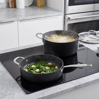 Ceramic nonstick cookware set by Alva Cookware; two black pots with lids on an induction cooktop on Tampa Home & Garden Store