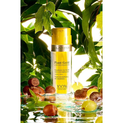 Clarins Plant Gold Nutri-Revitalizing Oil-Emulsion bottle with gold cap and oil near leaves on Tampa Home & Garden Store