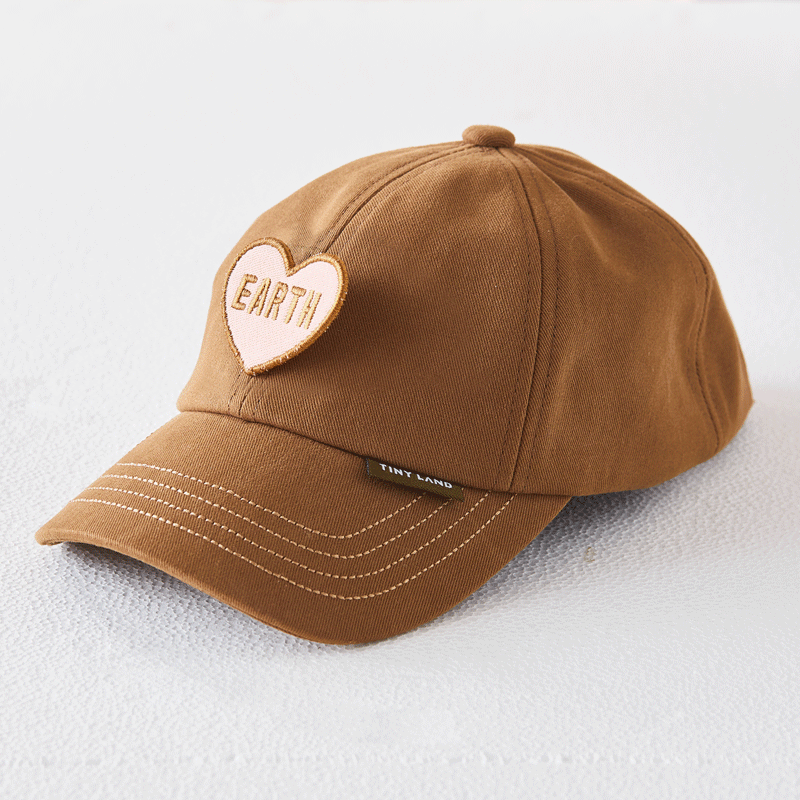 Brown baseball cap by Tiny Land with heart-shaped Earth patch and Tiny Land tag on the brim on Tampa Home & Garden Store