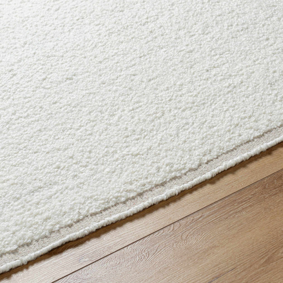 Niabi Area Rug by Boutique Rugs, cream shag with beige edge on hardwood floor on Tampa Home & Garden Store