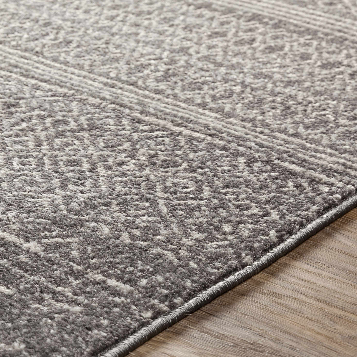 Mckinney Area Rug, gray textured plush by Boutique Rugs with a rolled edge on wood floor on Tampa Home & Garden Store