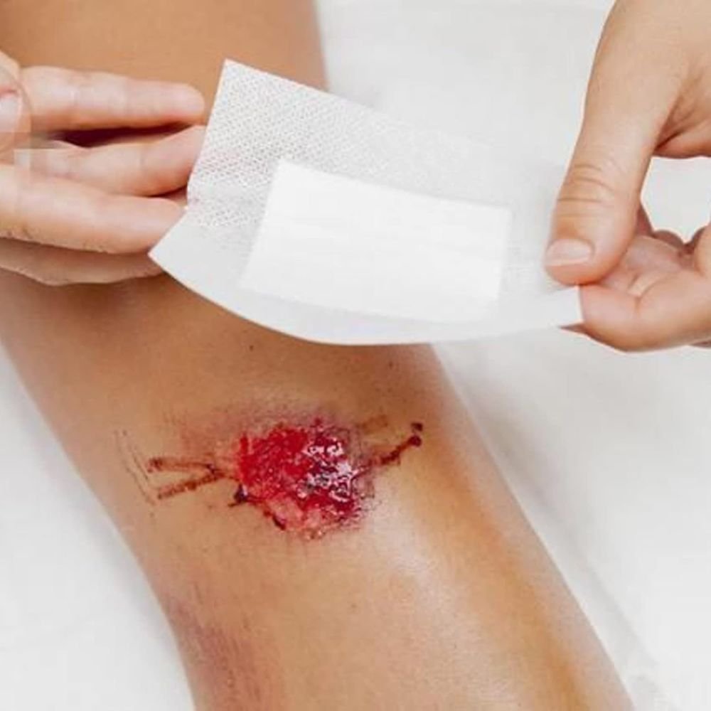 63-Piece First Aid Kit being used to cover a forearm wound with a white adhesive bandage on Tampa Home & Garden Store