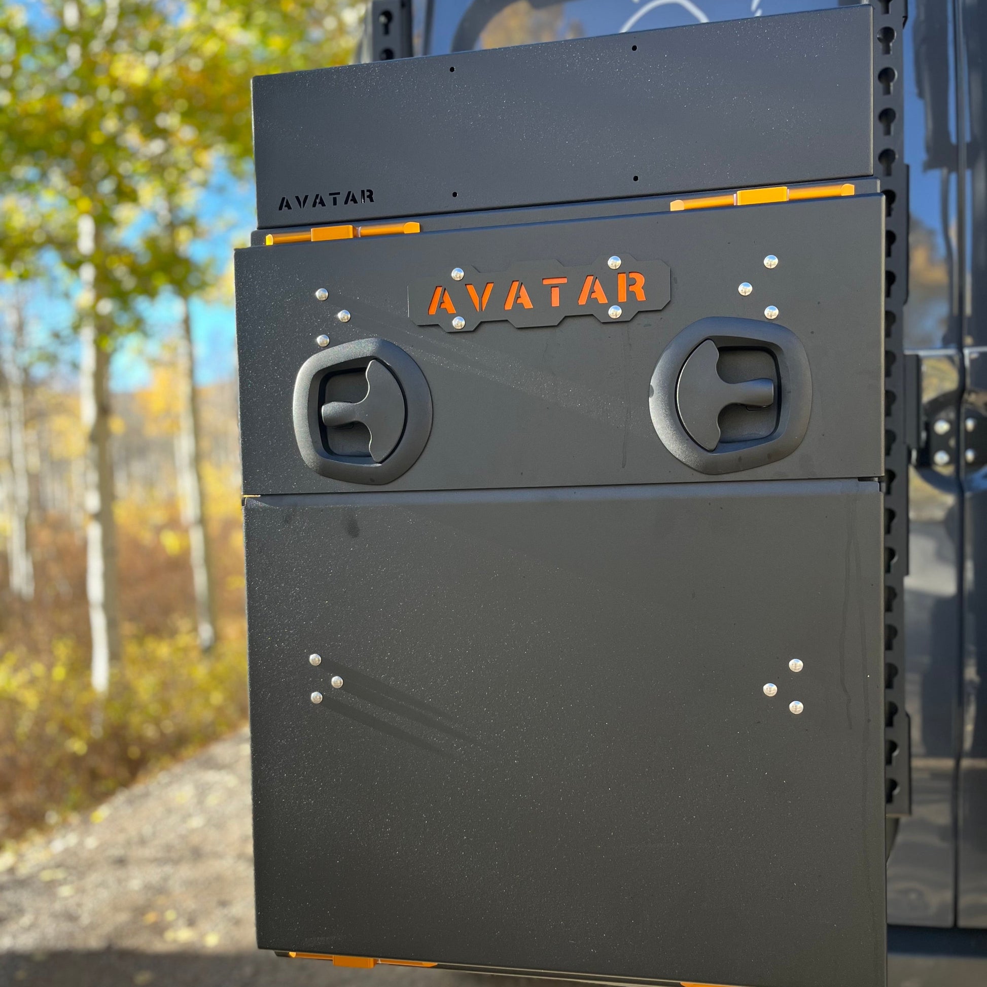 Avatar Niko Van Storage Box mounted on rack; dark gray with orange latches and Avatar logo on Tampa Home & Garden Store