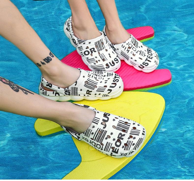 Stevvex men's white printed slip-on water sandals with black typography on colorful pool floats on Tampa Home & Garden Store