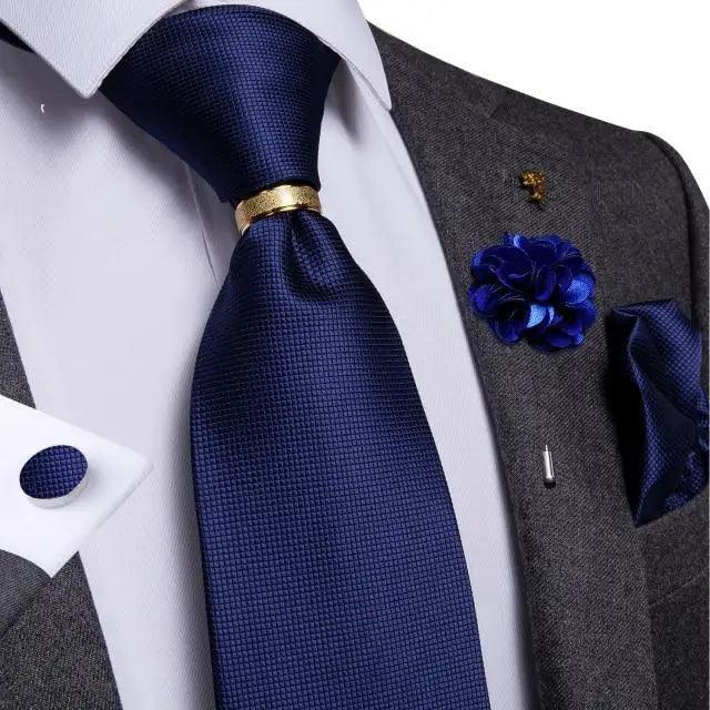 Navy blue silk necktie with gold tie bar paired with white shirt and gray suit on Tampa Home & Garden Store