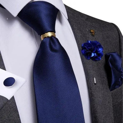 Navy blue silk necktie with gold tie bar paired with white shirt and gray suit on Tampa Home & Garden Store