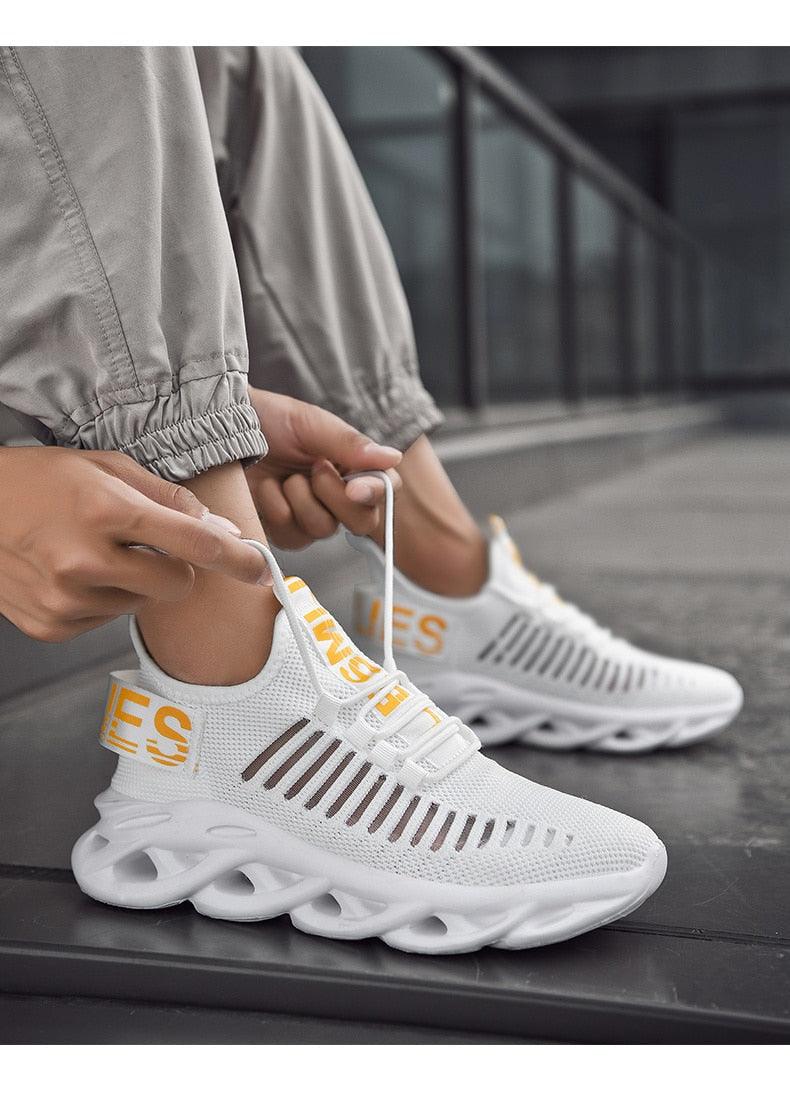 Men's Stevvex sneakers pair, white knit upper with yellow accents, cloud sole on Tampa Home & Garden Store